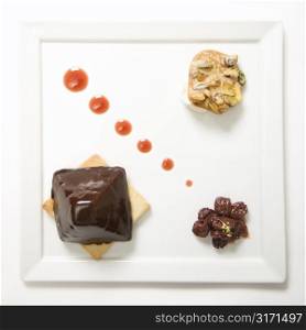 Chocolate cheesecake pyramid with dried cherries and pistachio praline.
