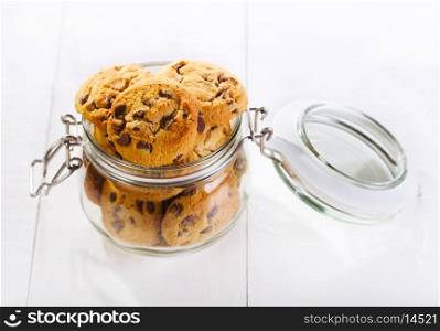 Chocolate chip cookies in a glass jar on wooden table