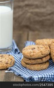 Chocolate chip cookies in rustic kitchen setting with glass of milk