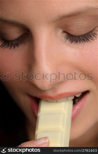 Chocolate - close-up of young woman bite sweets