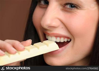 Chocolate - close-up of young woman enjoy sweets on brown background