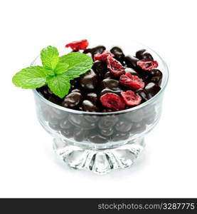 Chocolate coated cranberries in glass bowl on white background