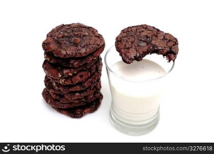 Chocolate Cookies And Milk. Rich dark chocolate cookies and a glass of cold milk. One cookie has a bite out of it