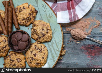 Chocolate cookies, on rustic wood next to cocoa in different forms