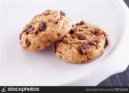 Chocolate cookies over white stand, shallow depth of field, horizontal image