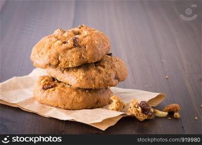 Chocolate Cookies Raisins are stacked three pieces on a wooden floor.