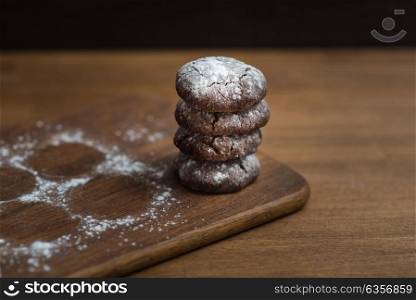 chocolate cookies with sugar powder on wooden kitchen Board