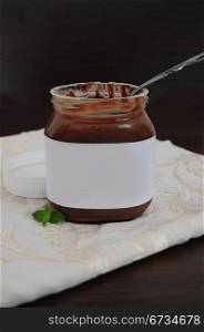 Chocolate cream in jar with spoon