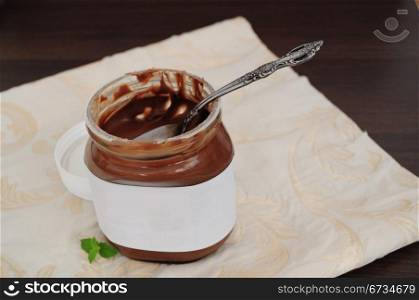 Chocolate cream in jar with spoon