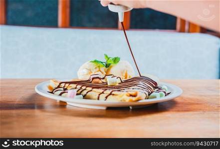 Chocolate crepe with ice cream on wooden background. Close up of sweet crepe with ice cream