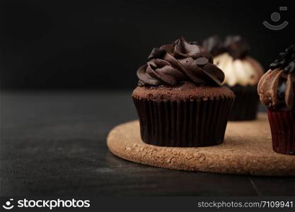 Chocolate cupcake on wooden plate in Dark lighting, AF point selection.