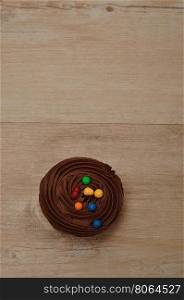 Chocolate Cupcake with chocolate frosting and decorated with colorful candy