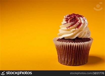 chocolate cupcake with cream isolated on orange background with copyspace