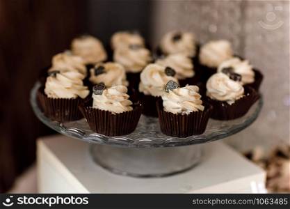 Chocolate cupcakes. Homemade chocolate muffins. The process of making homemade chocolate cupcakes with whipped cream and decorated with chocolate. Selective focus. Candy bar concept.