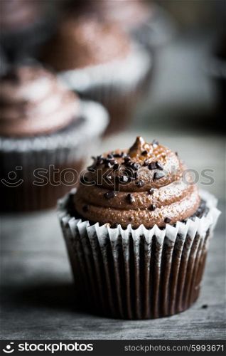 Chocolate cupcakes on rustic wooden background
