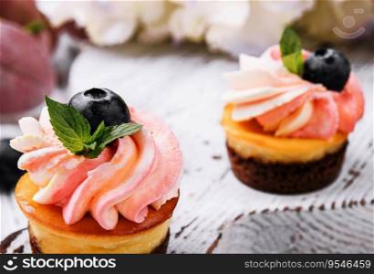Chocolate cupcakes with pink cream and fresh blueberry