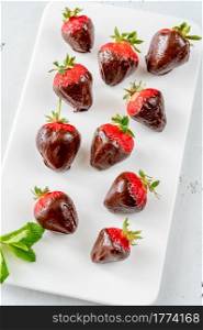 Chocolate-dipped strawberries on the white serving plate
