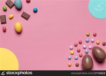 chocolate easter eggs gem candies with copy space writing text pink background_2