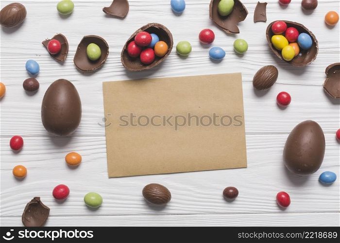 chocolate eggs candies around paper sheet