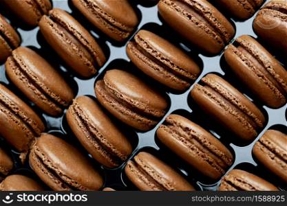 Chocolate-flavored French macarons are in the bakery.