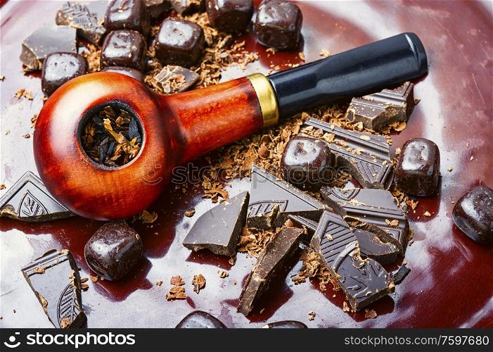 Chocolate flavored tobacco for smoking pipes.Tobacco pipe filled with tobacco.. Chocolate flavored tobacco pipe.