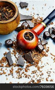 Chocolate flavored tobacco for smoking pipes.Tobacco pipe filled with tobacco.. Smoking pipe and tobacco