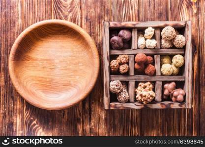 Chocolate handmade candies and empty wooden table, empty place for text. Chocolate candy box