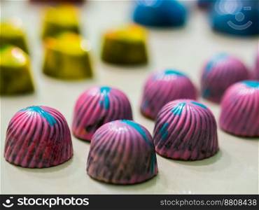 chocolate handmade candies. chocolates without heat treatment lie on wooden table with cracked paint on the surface. raw food diet concept. rustic style