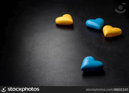 Chocolate hearts in the colors of the Ukrainian flag on a black ceramic plate. Valentine’s day in Ukrainian colors