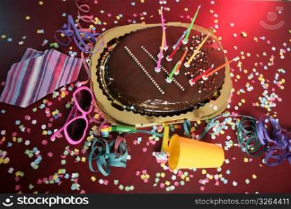 Chocolate holiday party cake on a messy confetti red table