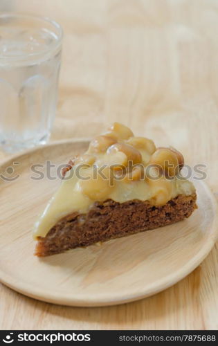 chocolate macadamia cake. Piece of chocolate macadamia cake on wooden plate