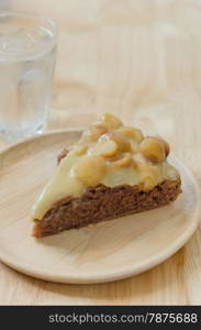 chocolate macadamia cake. Piece of chocolate macadamia cake on wooden plate