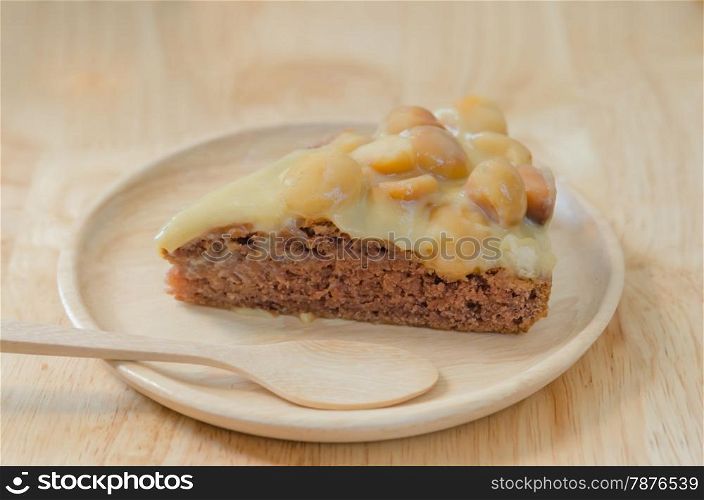 chocolate macadamia cake. Piece of chocolate macadamia cake on wooden plate