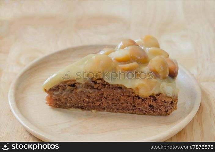 chocolate macadamia cake. Piece of chocolate macadamia cake on wooden plate