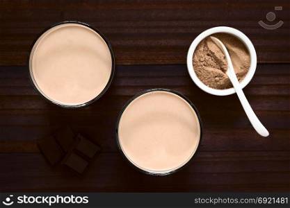 Chocolate milk drink in glasses, chocolate or cocoa powder on the side, photographed overhead with natural light (Selective Focus, Focus on the chocolate drinks). Chocolate Milk Drink