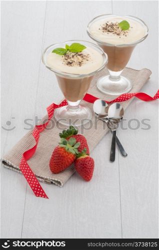 Chocolate mousse and strawberries on wooden table.