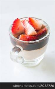 Chocolate Mousse topped with strawberries fruit in glass on white background