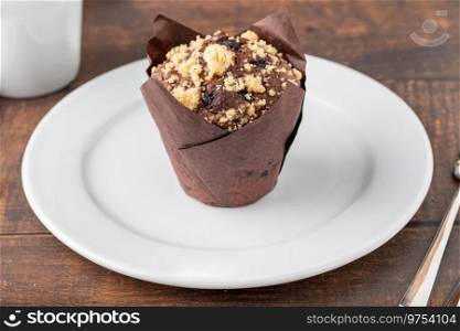 Chocolate muffin or cupcake with coffee on wooden table