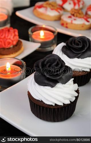 Chocolate muffin with cream decorated with black protein rose from marzipan