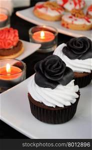 Chocolate muffin with cream decorated with black protein rose from marzipan