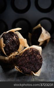 Chocolate muffins over dark background, selective focus