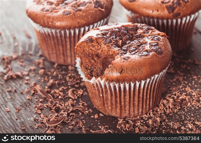 Chocolate muffins with chocolate chips on the wood background closeup