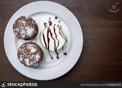chocolate muffins with ice cream drizzled with chocolate topping