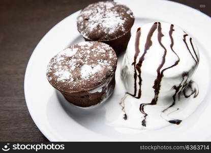 chocolate muffins with ice cream drizzled with chocolate topping