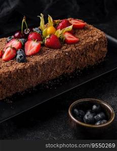 Chocolate Napoleon cake with berries on stone plate