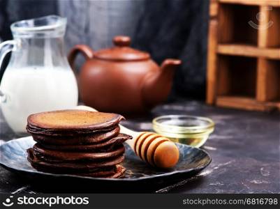 chocolate pancakes on plate and on a table