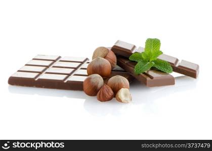 Chocolate parts and cinnamon sticks isolated on white background.
