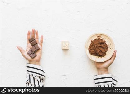chocolate pieces versus cocoa powder plate white textured background
