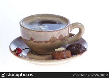 chocolate pralines cup with black coffee on white background. Delicious dark and milk chocolate pralines.
