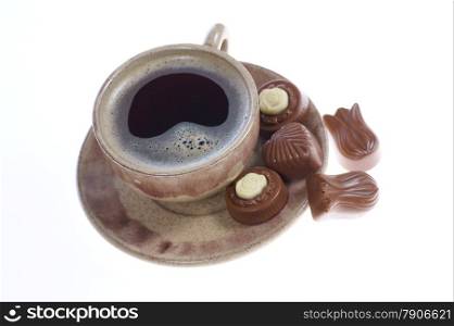 chocolate pralines cup with black coffee on white background. Delicious dark and milk chocolate pralines.